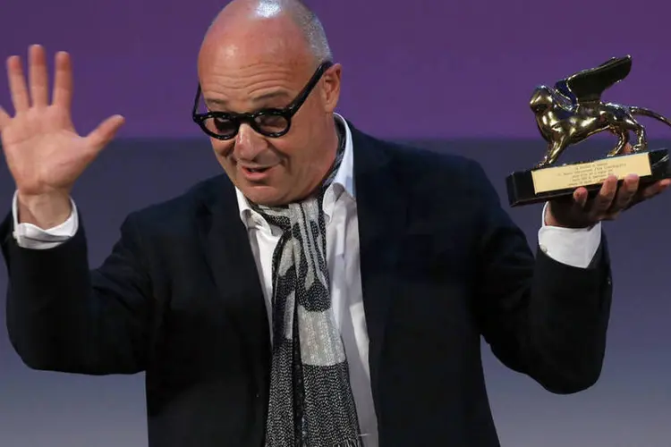 
	Diretor italiano Gianfranco Rosi segurando o Le&atilde;o de Ouro
 (REUTERS/Alessandro Bianchi)