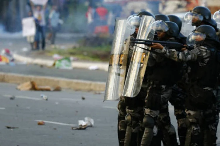 
	Policiais durante confronto antes de jogo da Copa das Confedera&ccedil;&otilde;es: pelo menos 230 mil brasileiros viajaram para assistir aos jogos nas seis cidades-sede do torneio.
 (REUTERS/Kai Pfaffenbach)
