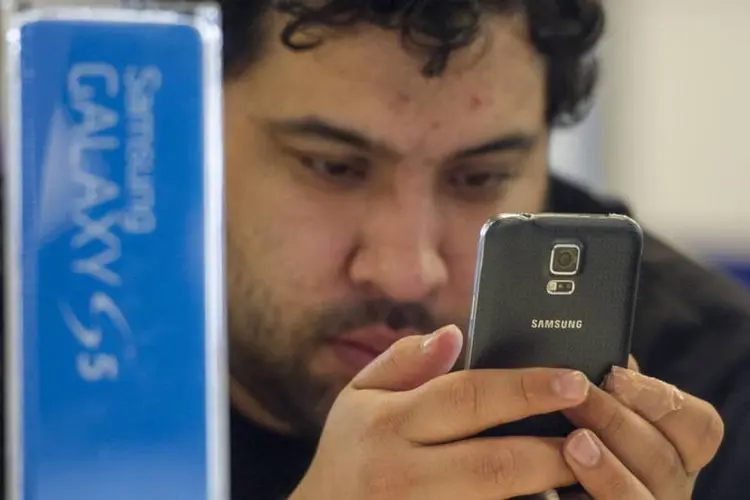 
	Consumidor olha o novo smartphone Galaxy S5: varejista viu lucratividade no produto
 (David Paul Morris/Bloomberg)