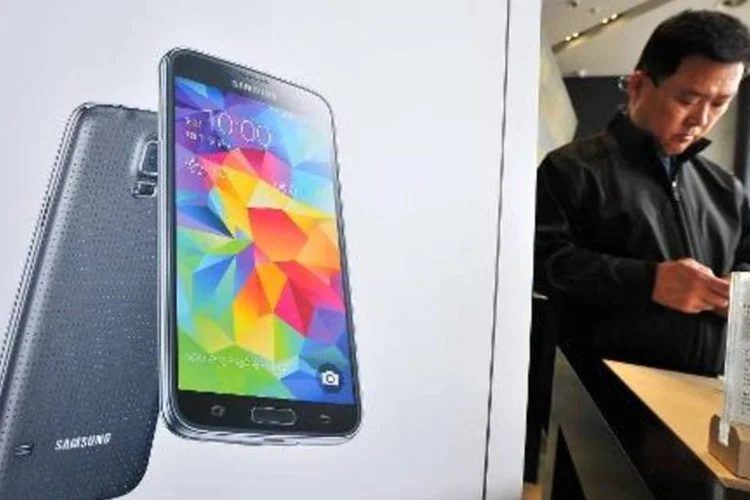 Cliente sul-coreano observa Samsung Galaxy S5 exposto em loja de Seul, em 27 de março de 2014 (Jung Yeon-Je/AFP)