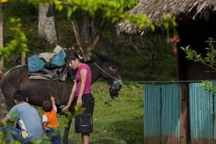Menino acaricia o cavalo, ao lado da família, em San Jose de Apartado: local é chamado de comunidade de paz (Luis Acosta/AFP)