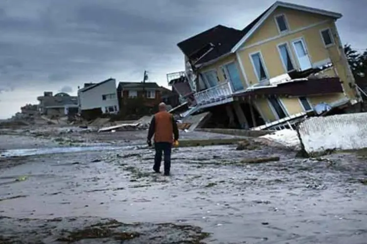 
	&nbsp;

	Homem observa casa tombada pela tempestade Sandy, em Queens, NY: o furac&atilde;o causou fortes ventos, tempestades e grandes inunda&ccedil;&otilde;es, al&eacute;m de perdas humanas e materiais