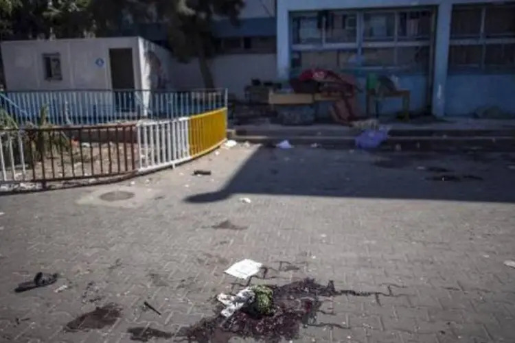 
	Po&ccedil;a de sangue na quadra da escola da ONU em Gaza, onde morreram 9 palestinos
 (Marco Longari/AFP)