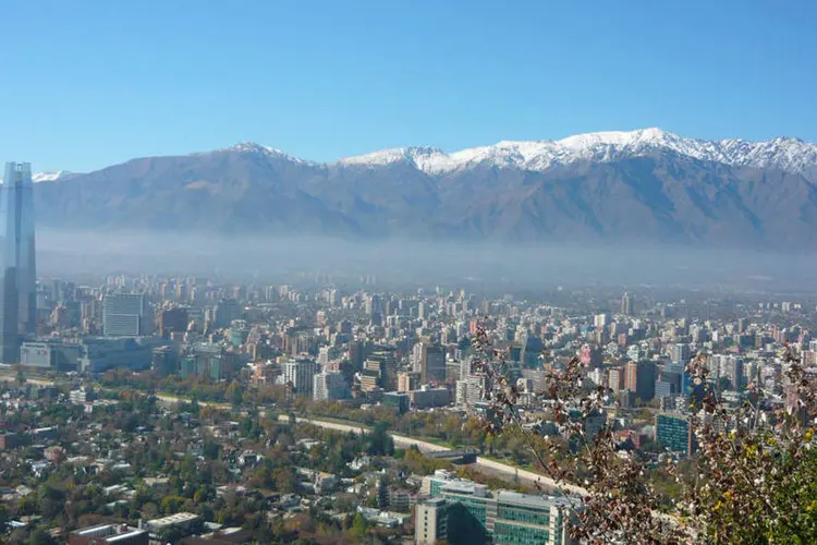 
	Com 6,3 milh&otilde;es de habitantes, Santiago est&aacute; situada em um vale rodeado de montanhas e &eacute; considerada uma das cidades mais polu&iacute;das da Am&eacute;rica Latina
 (Rawderson Rangel/Wikimedia Commons)