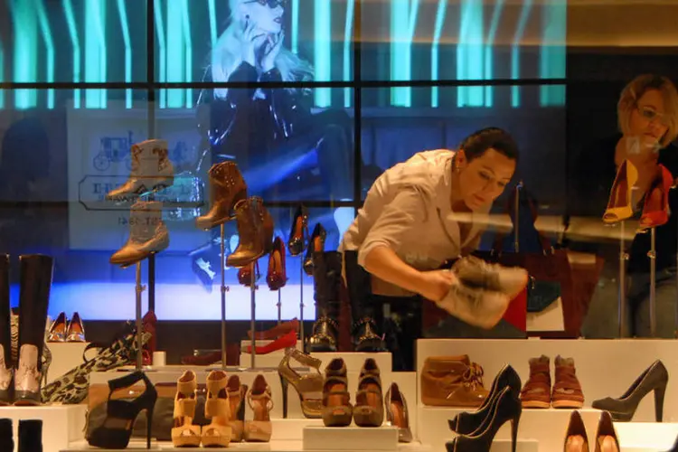 Mulher ajeita sapatos da vitrine de uma loja no Shopping Morumbi, em São Paulo (Mauricio Piffer/Bloomberg)