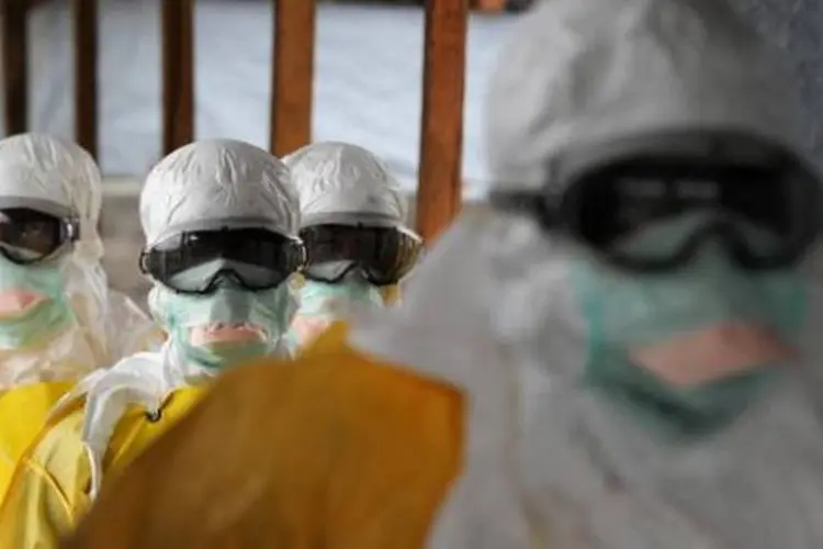 Funcionários da área da saúde usam roupas de proteção contra o ebola em hospital (Dominique Faget/AFP)