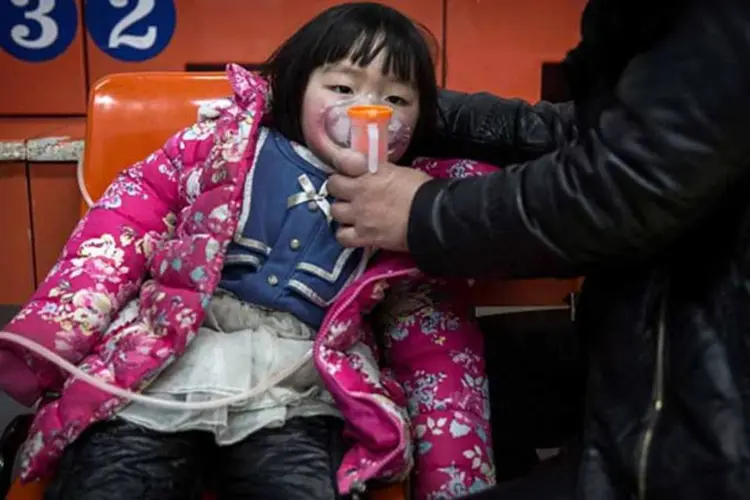 Danos: criança recebe oxigênio em um hospital de Pequim, durante dia de forte poluição na China (em 08/12/2015). (Kevin Frayer / Stringer)