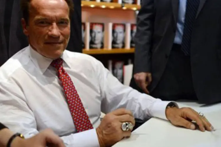 
	Arnold Schwarzenegger autografa exemplares de &quot;Total Recall&quot;: outro filme cl&aacute;ssico est&aacute; no forno
 (Johannes Eisele/AFP)
