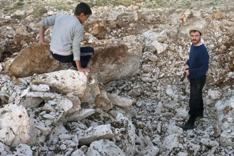 Sírios mostram o local supostamente destruído pela aterrissagem de um míssil Scud em Darret Ezza em 13 de dezembro
 (Herve Bar/AFP)