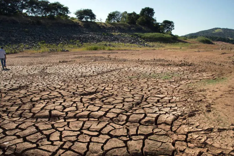 
	Homem caminha no solo seca da represa de Jaguari: a Sabesp divulgou uma tabela em seu site em que formaliza as cidades afetadas pela redu&ccedil;&atilde;o do abastecimento
 (Paulo Fridman/Bloomberg)