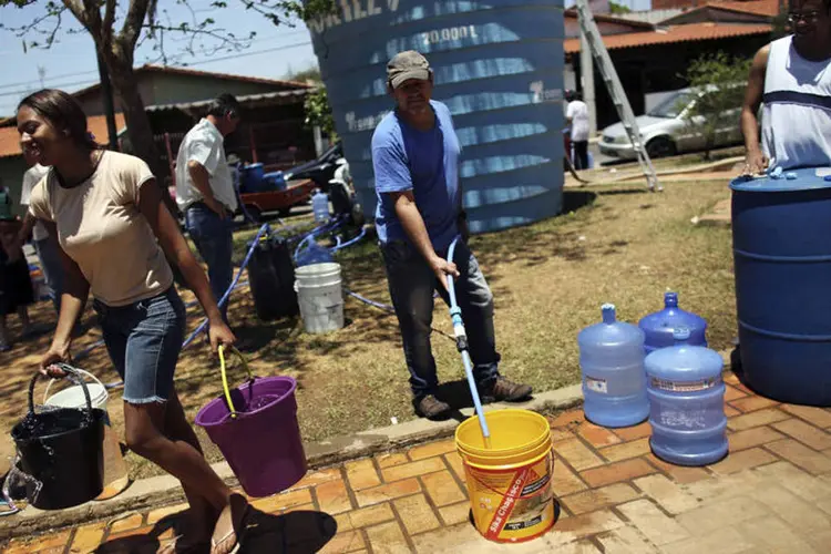 Moradores de Itu, que é abastecido pelo sistema Cantareira, enchem baldes com água em uma praça da cidade (Nacho)
