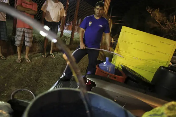 Moradores de Itu, que é abastecido pelo sistema Cantareira, enchem baldes com água em uma praça da cidade (Nacho Doce/Reuters)