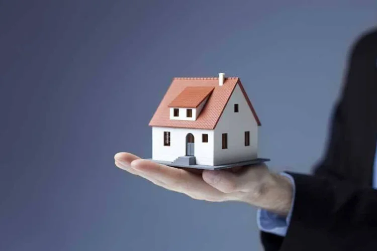 
	Homem segura casa em miniatura: financiamento do im&oacute;vel tem apenas dois seguros obrigat&oacute;rios
 (Bartłomiej Szewczyk/Thinkstock)
