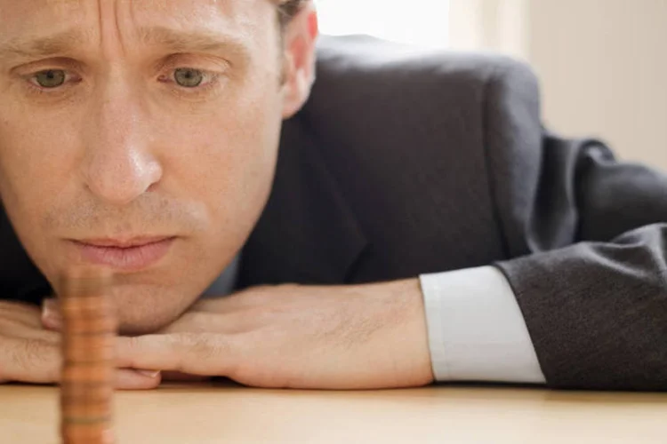 
	Homem preocupado diante de pilha de moedas: SPC Brasil aponta que 57% n&atilde;o se preocupam com a perda de renda nessa fase da vida
 (Creatas/Thinkstock)