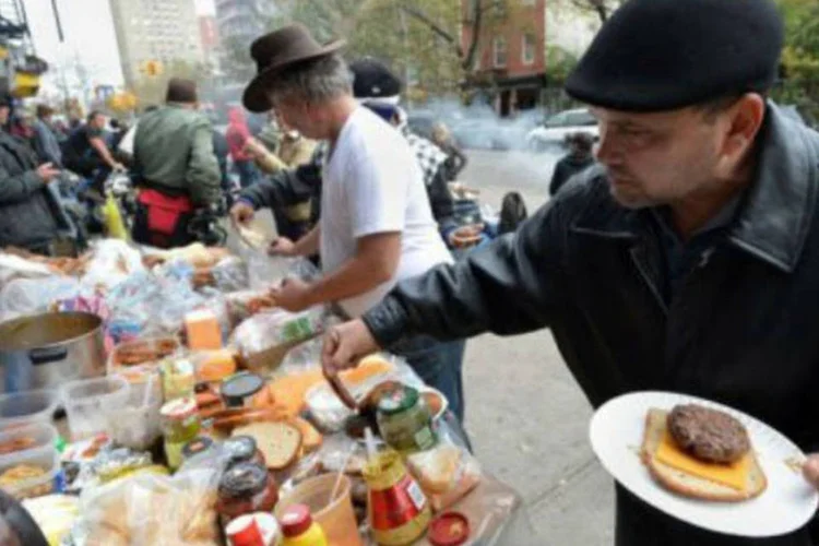 
	Moradores do East Village sem eletricidade preparam uma refei&ccedil;&atilde;o na rua: 70.000 lares de Nova York recuperaram a eletricidade desde quinta, mas 460.000 ainda continuam sem luz
 (Stan Honda/AFP)
