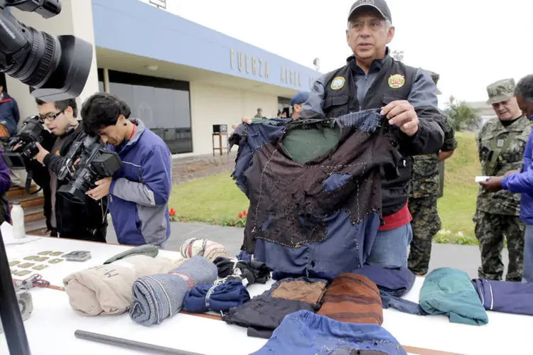 Policial peruano com as roupas de pessoas recuperadas em 2012 do cativeiro mantido pelo Sendero Luminoso (Wikipedia Commos)