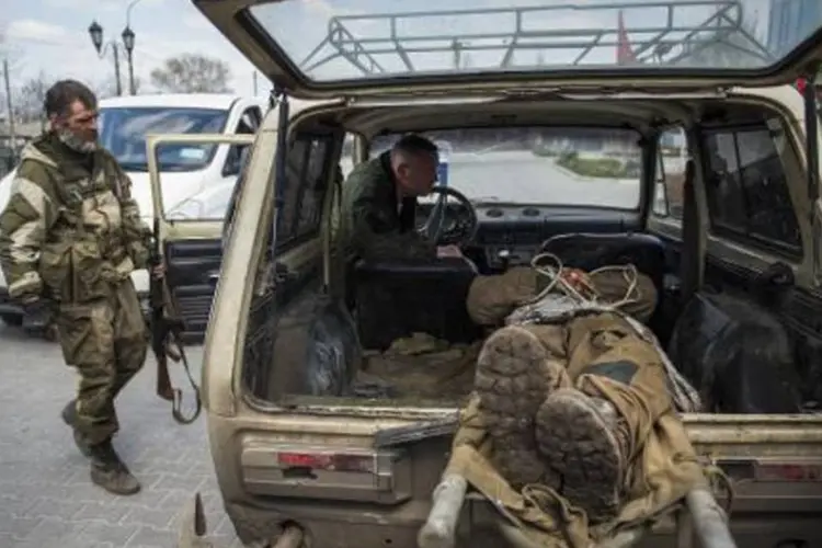 
	Soldado separatista do leste da Ucr&acirc;nia inspeciona corpo de soldado morto durante confrontos
 (Odd Andersen/AFP)