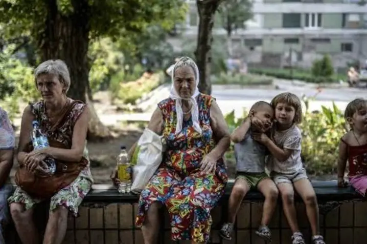 Refugiados em frente a um hotel tomado por separatistas pró-Rússia, no centro de Donetsk (Bulent Kilic/AFP)