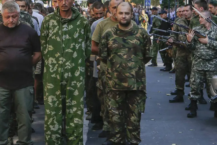 Separatistas pró-Russia escoltando prisioneiros ucranianos durante um desfile de provocação em Donetsk (Maxim Shemetov/Reuters)