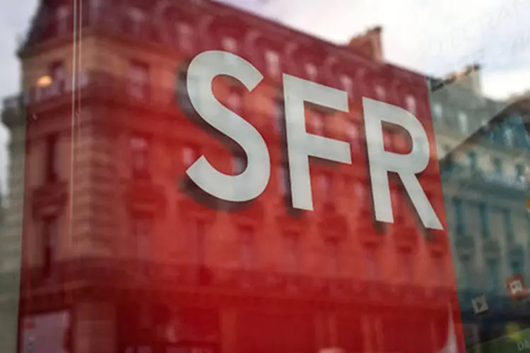 
	Pr&eacute;dios aparecem refletidos em vitrine de uma loja da SFR, em Paris, na Fran&ccedil;a: outras duas ofertas ainda podem ser feitas
 (Balint Porneczi/Bloomberg)