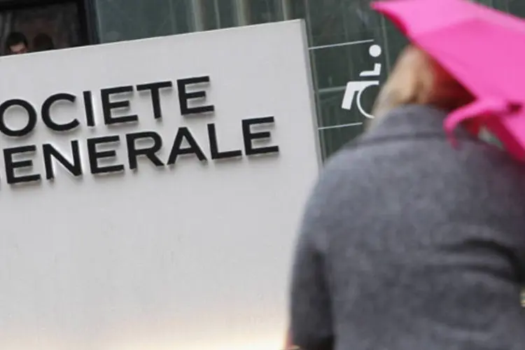Funcionária do banco Société Générale caminha em frente a sede da companhia próxima de Paris, França (Pascal Le Segretain/Getty Images)