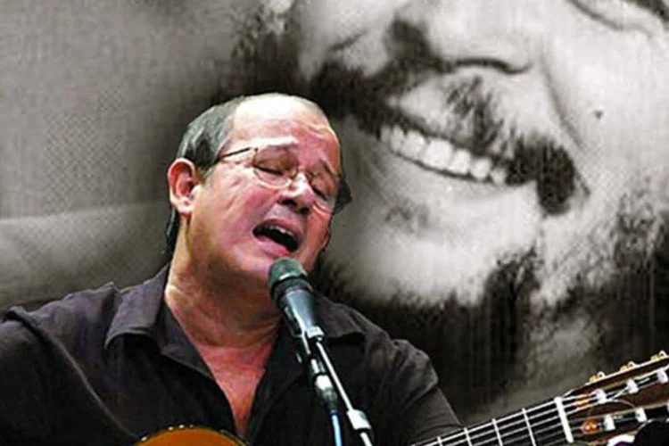 Músico cubano Silvio Rodríguez tocando junto com uma imagem de Che Guevara (Wikimedia Commons)