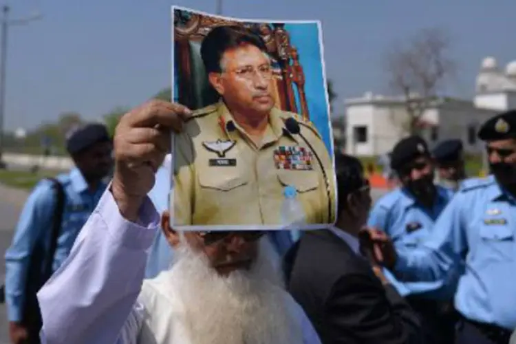 Simpatizante de Musharraf exibe foto do ex-comandante do exército perto do tribunal especial de Islamabad: audiência havia sido adiada diversas vezes por motivos de segurança (AFP)