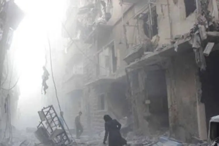 Mulher caminha por rua completamente destruída em Aleppo
 (Karam al-Masri/AFP)