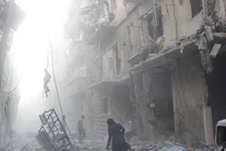 Mulher caminha por rua completamente destruída em Aleppo
 (Karam al-Masri/AFP)