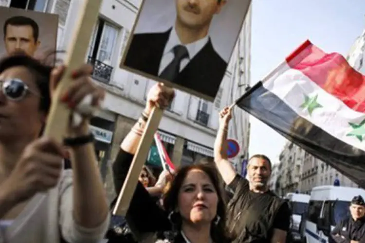 Simpatizantes do presidente sírio Bashar al-Assad se manifestam em frente ao centro cultural sírio em Paris
 (Guillaume Baptiste/AFP)
