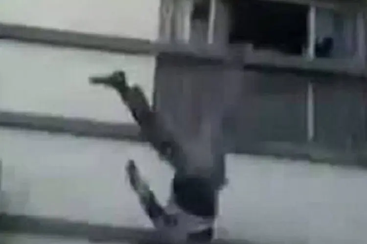 Imagem tirada do vídeo mostra corpo supostamente atirado do edifício dos correios em Alepo por rebeldes sírios
 (AFP)
