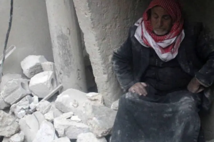 Em Aleppo, na Síria, um homem se senta no meio dos destroços de sua casa após um bombardeio feito pelas forças do governo. (19/1/2014)
 ( REUTERS/Hosam Katan)