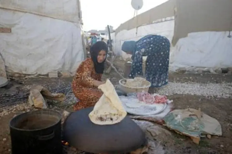 Sírias cozinham em um campo de refugiados: muitas vítimas não têm sequer comida (Matthieu Alexandre/AFP)