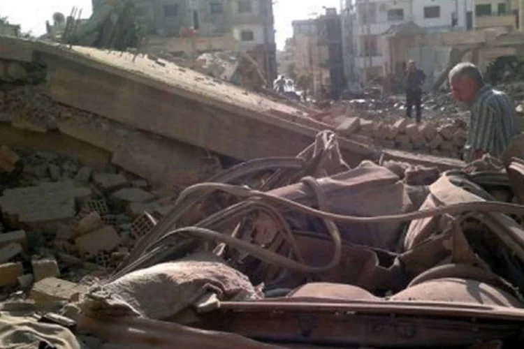 
	S&iacute;rios observam &aacute;rea de ataque em Qamishli: um proj&eacute;til similar j&aacute; havia ca&iacute;do em Ak&ccedil;akale na sexta-feira passada, derrubando uma casa e danificando seis lojas
 (Sana/AFP)