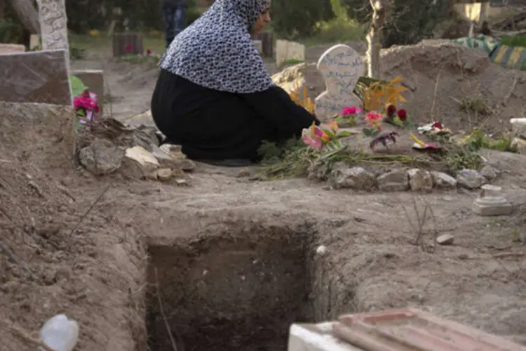 Mulher chora no túmulo de seu filho que foi morto durante confrontos: ativistas e autoridades disseram que a maioria dos mortos era de civis, incluindo crianças (Khalil Ashawi/Reuters)