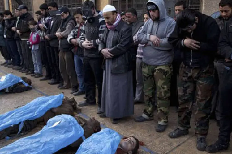 
	Homens rezam diante dos corpos dos civis executados, em Aleppo: &quot;N&atilde;o sabemos quem eles s&atilde;o porque est&atilde;o sem seus documentos de identidade&quot;, declarou um volunt&aacute;rio
 (AFP/ Jm Lopez)