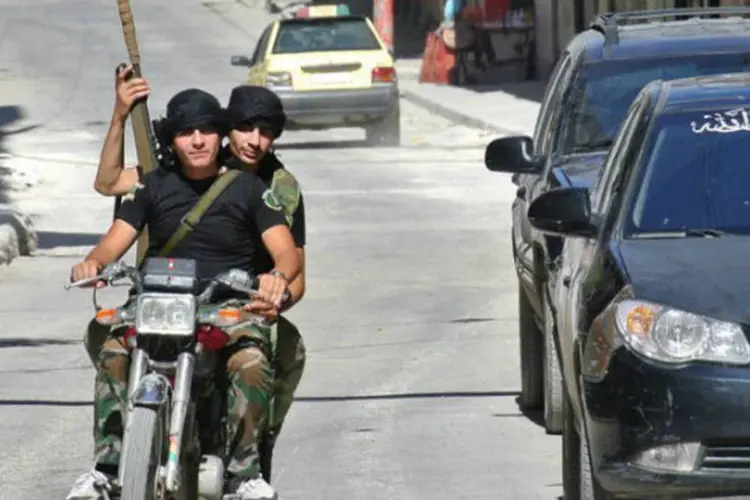 Rebeldes andam de moto em rua de Aleppo, na Síria (AFP)