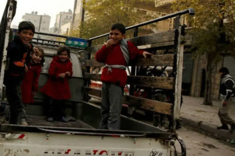 Crianças brincam em caçamba de caminhonete em Aleppo, na Síria (©afp.com / Prashant Rao)