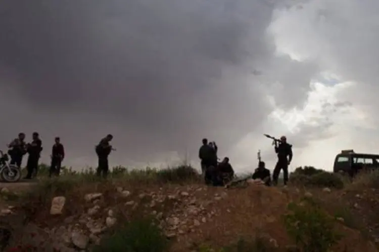 Rebeldes sírios montam guarda perto de Qusair no dia 10 de maio, onde execuções sumárias são frequentes (AFP)