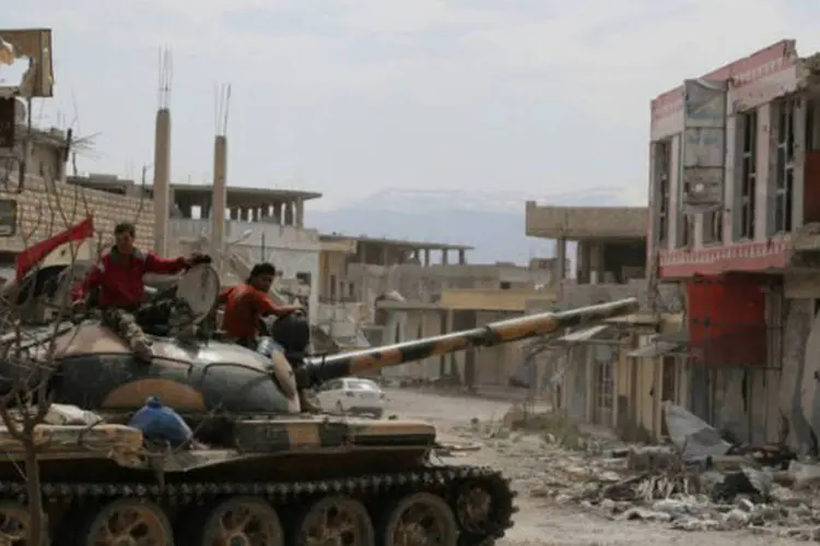 Soldados sírios em tanque na cidade de Qousseir, na província central de Homs (AFP)