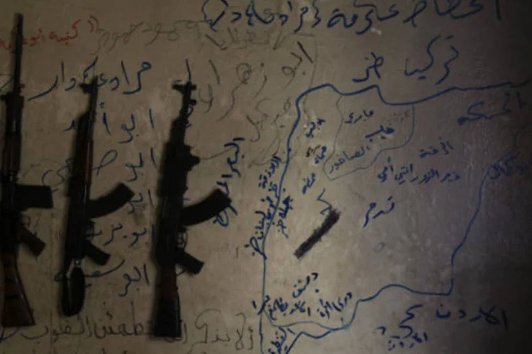 Armas são vistas ao lado de mapa da Síria desenhado na parede de casa de rebeldes em Alepo (REUTERS/Muzaffar Salman)