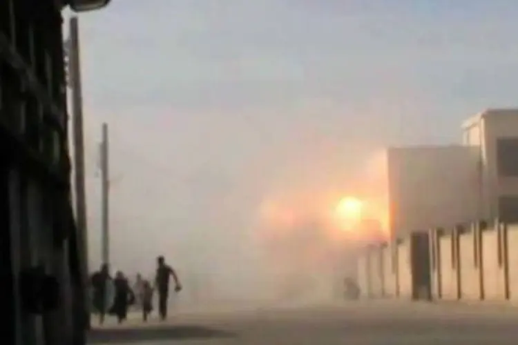 Uma imagem obtida de um vídeo postado no YouTube mostra uma família correndo em meio a combates em Homs
 (AFP)