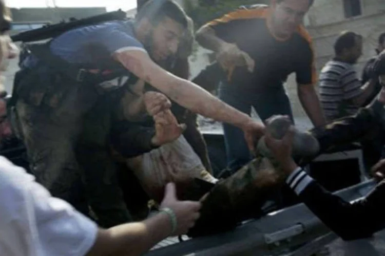 Combatentes transportam feridos durante confrontos com as forças do regime de Bashar al-Assad
 (Ricardo García Vilanova/AFP)