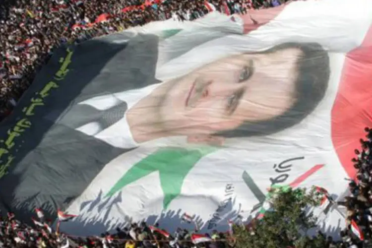 No centro da capital, os manifestantes agitavam bandeiras e retratos de Assad, ao som de canções patrióticas
 (Louai Beshara/AFP)
