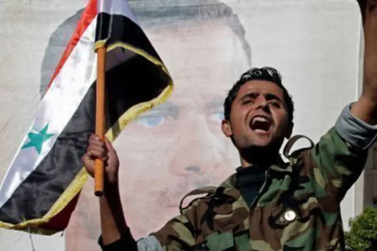 Soldado sírio grita em ato de apoio ao regime: apesar da pressão internacional, o aparelho repressivo do regime sírio não deu trégua
 (Luai Beshara/AFP)