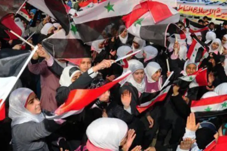 Escolares sírios realizam passeata em Damasco em apoio ao presidente (Sana/AFP)