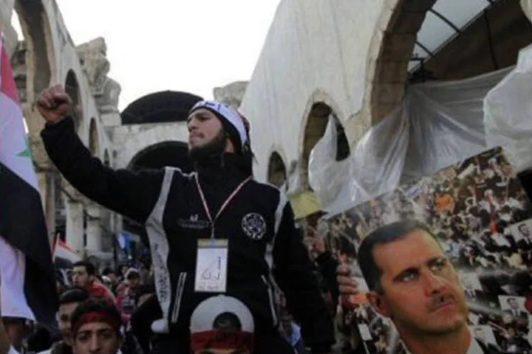 Em uma incomum aparição pública, Assad falou em uma praça no centro da capital, onde seus partidários acenavam bandeiras e exibiam fotografias suas (Joseph Eid/AFP)