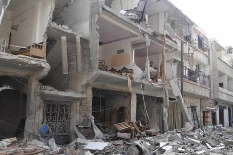 
	Homem caminha entre escombros de casas destru&iacute;das: &quot;(Maqdesi) saiu da&nbsp;S&iacute;ria&nbsp;h&aacute; dois dias e viajou para Londres. Entrou em contato conosco de forma indireta&quot;, afirmou Sarmini
 (Bassam al-Erbeeni/Reuters)