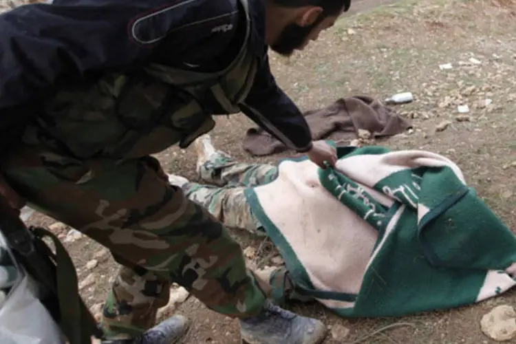 
	Soldado do ex&eacute;rcito livre da S&iacute;ria cobre o corpo de soldado leal ao presidente s&iacute;rio Bashar al-Assad
 (Zain Karam/Reuters)