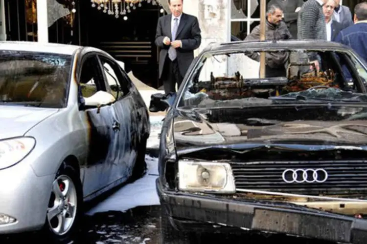 
	Carros s&atilde;o danificados ap&oacute;s duas explos&otilde;es em Damasco em 12 de dezembro: as bombas tamb&eacute;m causaram danos materiais
 (AFP)